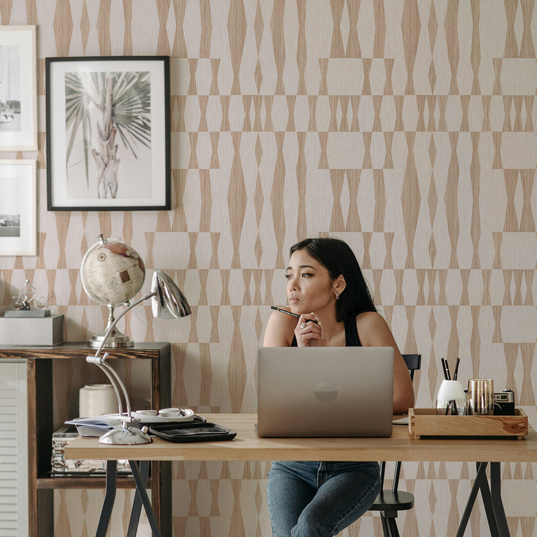 Faux Grasscloth Geo Removable Wallpaper - A wood desk with a college student sitting lost in thought in front of a wall featuring neutral Faux Grasscloth Geo Peel And Stick Wallpaper in textured jute | Tempaper#color_textured-jute