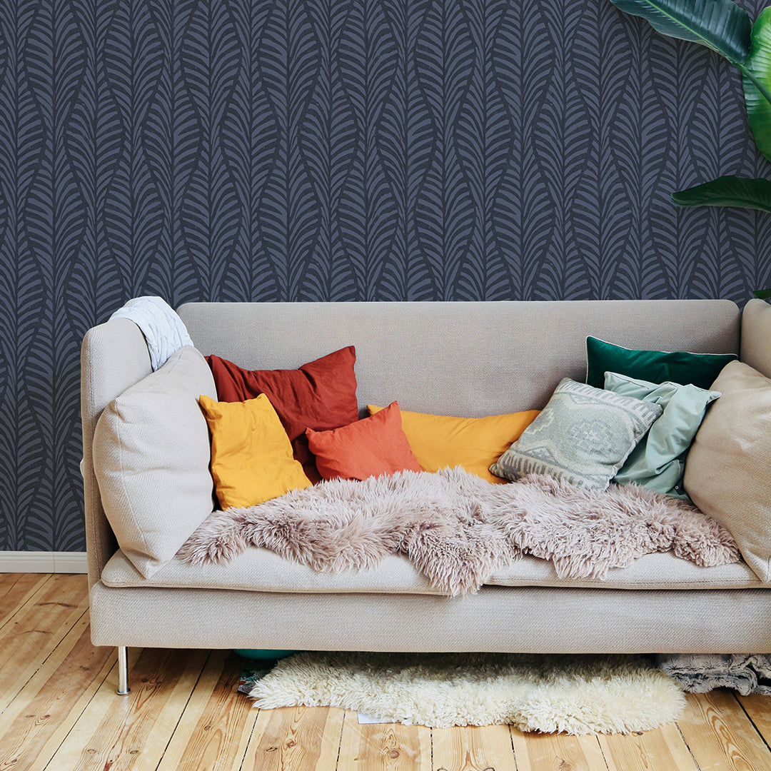 A college apartment living space with a neutral couch in front of a wall featuring a block print removable wallpaper. #color_indigo-blocks