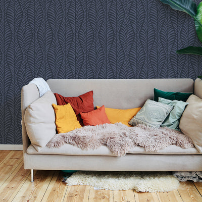 A college apartment living space with a neutral couch in front of a wall featuring a block print removable wallpaper. #color_indigo-blocks