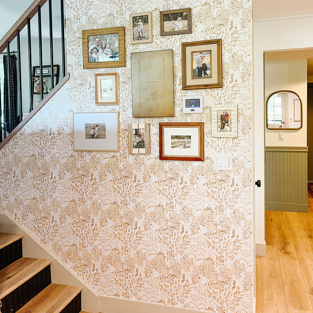 Golden wheat color stencil foliage wallpaper on a gallery wall along stairs #color_golden-wheat