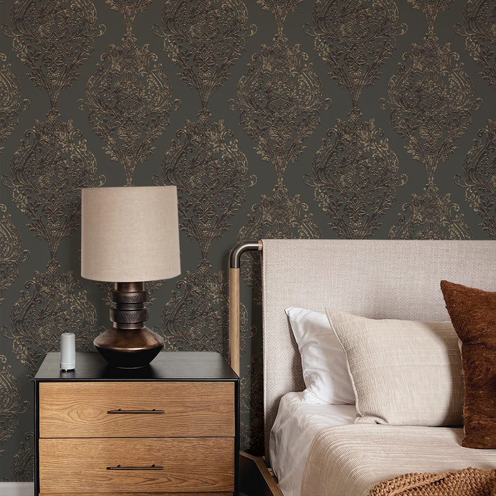 Estate Damask Non-Pasted Wallpaper - A bedroom and nightstand in front of Estate Damask Unpasted Wallpaper in charcoal damask | Tempaper#color_charcoal-damask