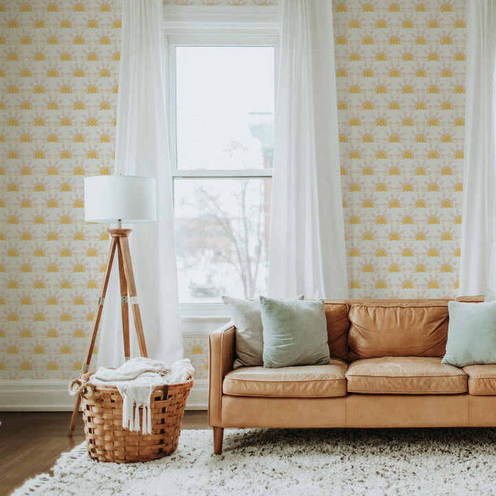 Tempaper's Sun Peel And Stick Wallpaper with a brown leather couch and laundry basket.