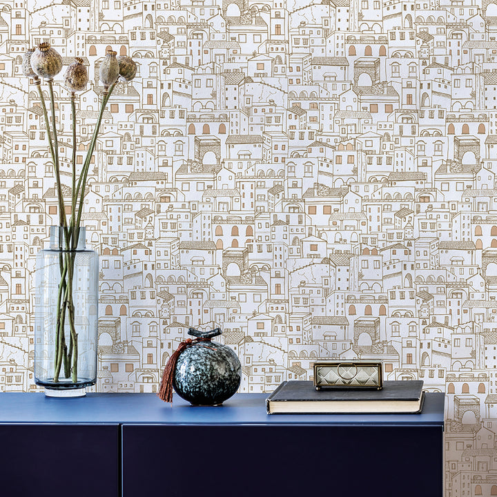 Amalfi WALLPAPER in metallic gold behind a long table with flowers and a vase.