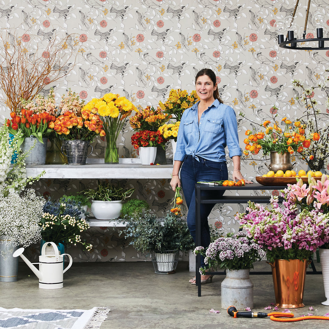 Cortney Novogratz standing in front of Birds WALLPAPER with flowers.