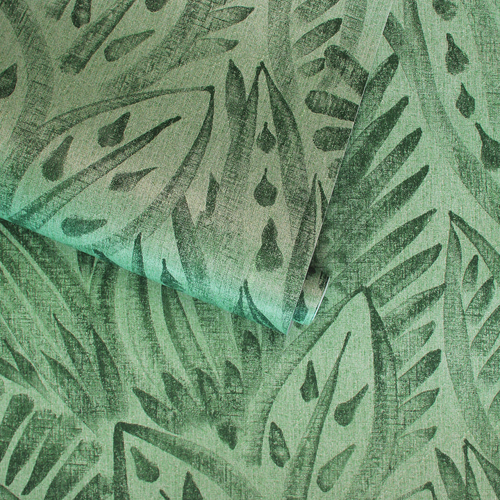 A slightly unraveled roll of Canvas peel and stick wallpaper in a dark green colorway.