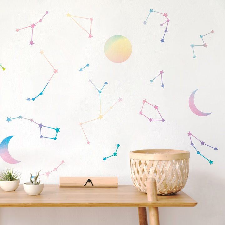 A side table in front of a wall decorated with holographic Constellations & Moons wall decals from Tempaper.