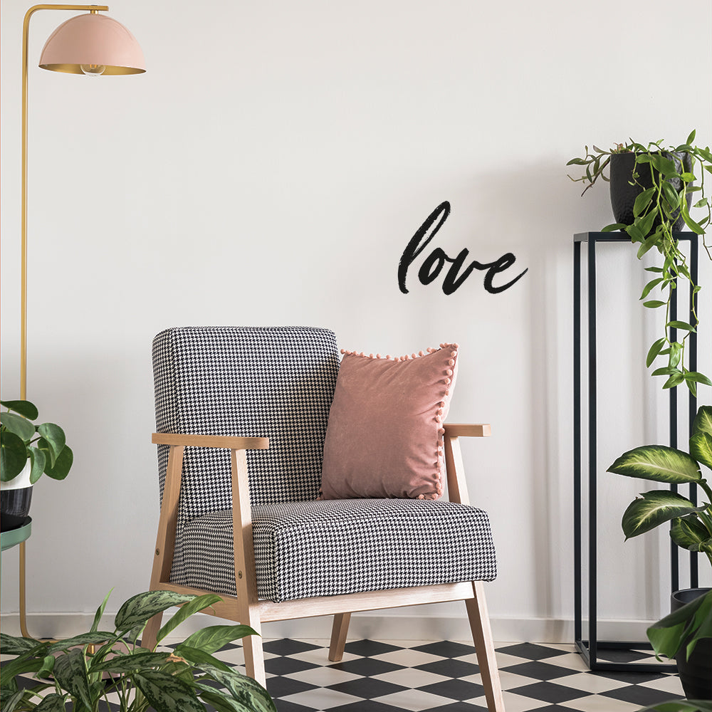 A plant room with checkered flooring and black and white chair accents by Tempaper's Love wall decal on the wall behind.