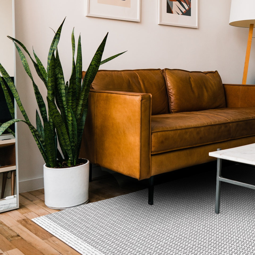 Tempaper's Diamond Geometric Vinyl Rug shown under a couch and table.